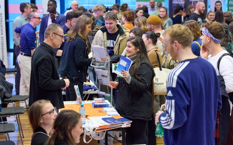 Studierende stehen bei den Ständen und informieren sich