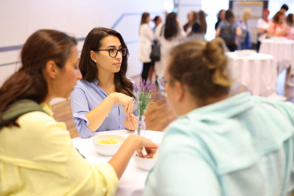 Drei Frauen en einem Tisch unterhalten sich