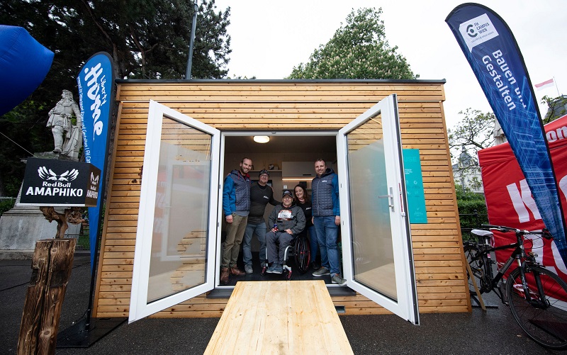 Mehrere Menschen im Tiny House mit Rollstuhlrampe am Wiener Rathausplatz