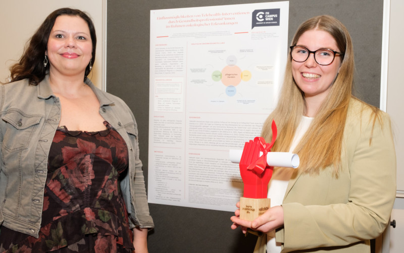 zwei Frauen vor einem wissenschaftlichen Plakat