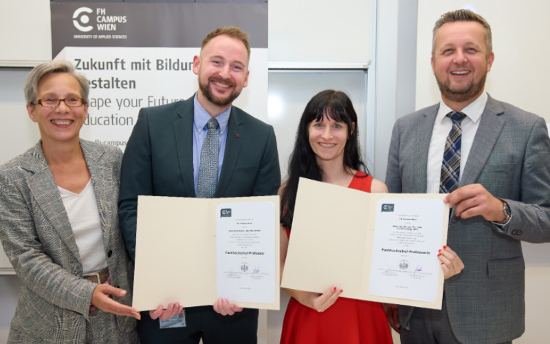 © HCW / Schedl vier Personen, die zwei in der Mitte mit einem Diplom in der Hand