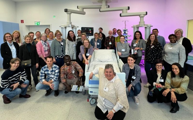 Einge Gruppe von Personen rund um ein Krankenbett mit monitoren und pflegerisch technischen GerätenGeräten 