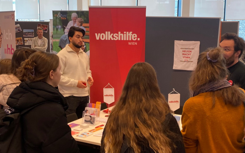 eine Gruppe von Personen um einen Tisch vor Rollups