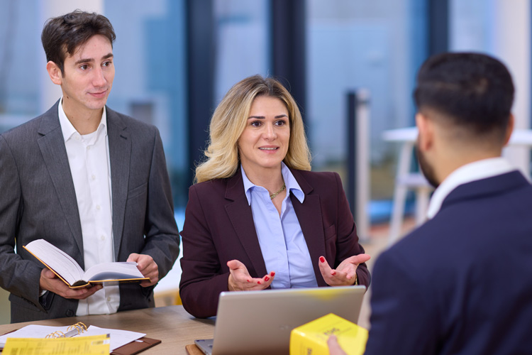 Drei Menschen, ein Mann und eine Frau beraten einen Mann.