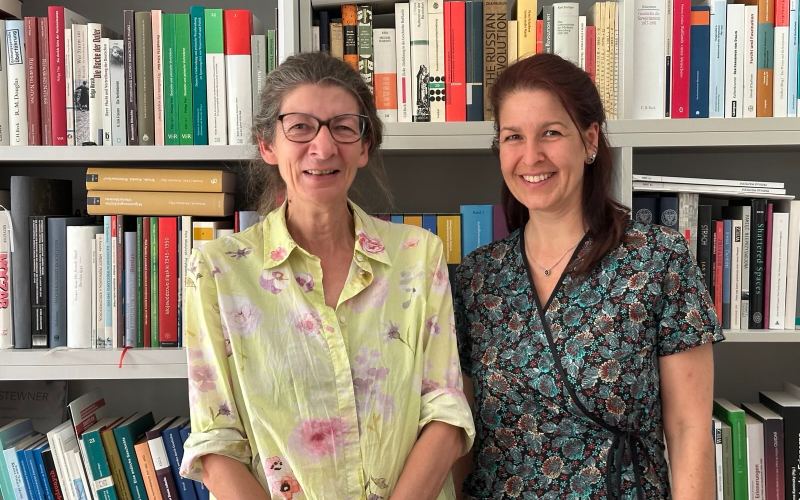 Claudia Kraft mit Irene Messinger vor Bücherregal 