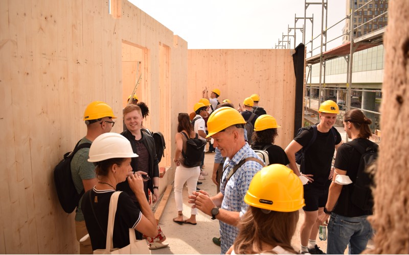 Exkursionsteilnehmer mit Bauhelmen auf einer Baustelle