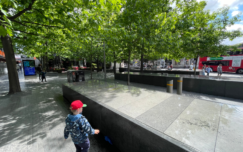 Ein Kind auf einem begrünten Londoner Platz. 