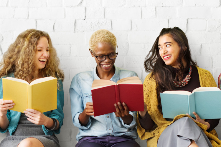 Drei weibliche Studierende, lächelnd. 